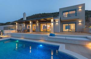a villa with a swimming pool in front of a house at Artisan's House in Sitia