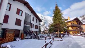 a building with a christmas tree in the snow at La casa nel cuore di La Thuile in La Thuile