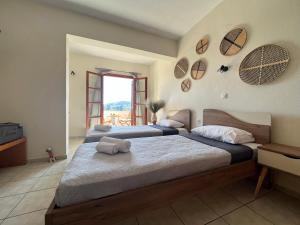 1 dormitorio con 2 camas y ventana en Jimmy's Guest House Skiathos, en Skiathos