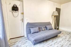 - un canapé bleu dans le salon avec une lampe dans l'établissement Le 15 - Appartement pour 4 personnes - Disneyland Paris, à Esbly
