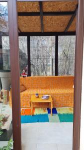 Cozy apartment with balcony في صوفيا: غرفة معيشة مع أريكة برتقالية وطاولة