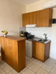 a kitchen with wooden cabinets and a sink at Jimmy's Guest House Skiathos in Skiathos Town