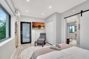 a bedroom with a large bed and a chair at 2 Condo Combo - Walk to Beach Off Las Olas 1AB in Fort Lauderdale