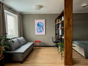 ein Wohnzimmer mit Sofa und Bücherregal in der Unterkunft Grey studio in Maardu in Maardu