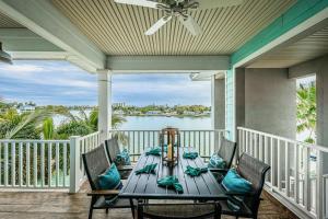 a dining table on a porch with a view of the water at Treasure Trove Flying Dutchman in St Pete Beach