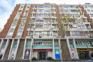 a tall building with a tree in front of it at BBarcelona Encants Flat in Barcelona