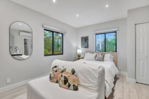een witte slaapkamer met een bed en een spiegel bij Studio Right off Las Olas - Steps to FTL Beach 2C in Fort Lauderdale