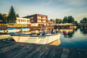 a boat is docked at a dock in the water at Hotel Port 110 in Iława
