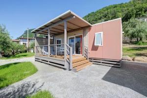 een roze tiny house met een veranda bij Camping Eurovil in Predore