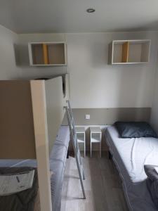 una habitación con 2 camas y una escalera. en Mobil home 7 couchages, en Ouistreham