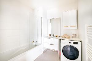 W białej łazience znajduje się pralka. w obiekcie Appartement T2 neuf - Grande Terrasse de 25m2 w mieście Saint-Priest
