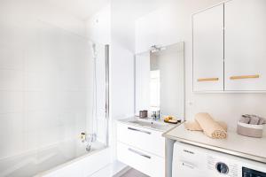 biała łazienka z umywalką i wanną w obiekcie Appartement T2 neuf - Grande Terrasse de 25m2 w mieście Saint-Priest +12 zdjęć