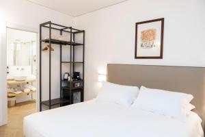 1 dormitorio con cama blanca y estante negro en Domus Vitra, en Roma
