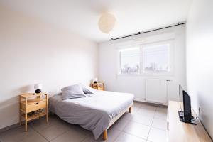 - une chambre blanche avec un lit et une télévision dans l'établissement Appartement T2 neuf - Grande Terrasse de 25m2, à Saint-Priest