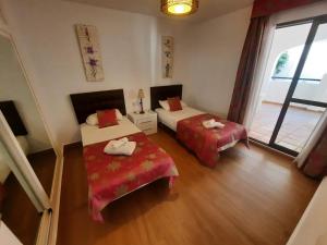 ein Hotelzimmer mit 2 Betten und einem Fenster in der Unterkunft 2 bedroom apartment with pool and barbecue in Benalmádena