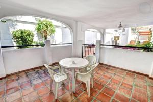 een eetkamer met een tafel en stoelen op een balkon bij 2 bedroom apartment with pool and barbecue in Arroyo de la Miel