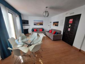 een woonkamer met een glazen tafel en witte stoelen bij 2 bedroom apartment with pool and barbecue in Arroyo de la Miel