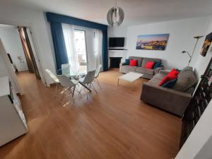 een woonkamer met een bank en een glazen tafel bij 2 bedroom apartment with pool and barbecue in Arroyo de la Miel