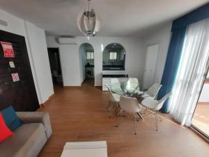 een woonkamer met een glazen tafel en stoelen bij 2 bedroom apartment with pool and barbecue in Arroyo de la Miel