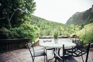 a table and chairs on a patio with a view at Haus Elisabeth in Santa Gertrude nella Val d'Ultimo