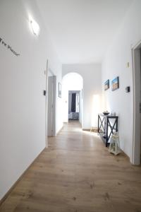 un pasillo con paredes blancas y suelo de madera en Residence Le Tre Piazze, en Siracusa