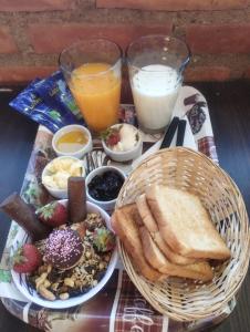 uma bandeja de comida para o pequeno-almoço com torradas, pão e leite em Alas Cabañas em El Bolsón