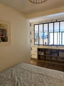 a bedroom with a bed and a large window at Le nuage des balmes in Caluire-et-Cuire