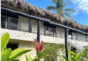 un edificio resort con techo de paja en El Rincon de Abi, en Las Terrenas