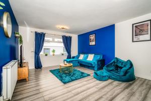 a living room with blue walls and a blue couch at A Gem in Greenock - Sleeps 8 in Greenock