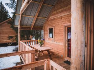 drewniany domek z drewnianym stołem na ganku w obiekcie Huttopia Bozel en Vanoise w mieście Bozel
