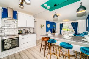 a kitchen with white cabinets and blue stools at A Gem in Greenock - Sleeps 8 in Greenock