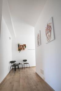 Habitación con 2 sillas y una mesa en una pared blanca. en Residence Le Tre Piazze, en Siracusa