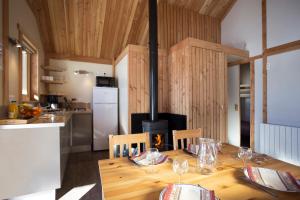 kuchnia z drewnianym stołem i kuchenką w obiekcie Huttopia Bozel en Vanoise w mieście Bozel