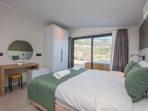 sypialnia z dużym łóżkiem i dużym oknem w obiekcie Asfiya Loft Apartments w Kaş