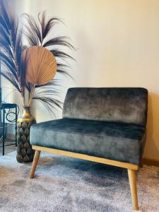 a bench in a living room with a plant at Au calme de la Gaité in Saint-Jacques-de-la-Lande