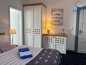 Schlafzimmer mit einem Bett mit blauer und weißer Bettwäsche in der Unterkunft Pension Marie Luise 253 - Zimmer Meerschnecke in Juist