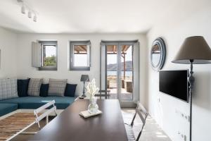 sala de estar con sofá azul y mesa en Ammoa Beach Residences en Vayia