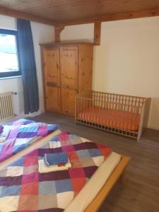 a bedroom with a crib and a bed in a room at Haus Heidelberg in Feldberg
