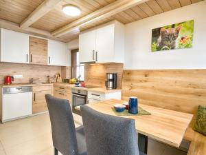 - une cuisine avec une table et des chaises en bois dans l'établissement Bio-Kinderbauernhof Wilmershof, à Titisee-Neustadt