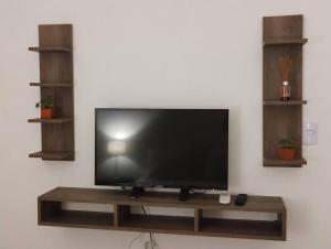 a flat screen tv sitting on a wooden shelf at Hospedaje La Bussola II in Gualeguaychú