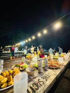 a table with food on it with people at night at The Secret Garden Camping - Hồ Trị An 