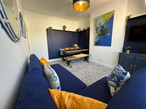 a living room with a blue couch and a table at Seaside Apartment close to beach, town, station in Broadstairs