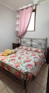 een slaapkamer met een bed met een bloemenbed bij Appartamento da Raffaella CIR O12133 CNI OOO39 in Varese