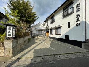 an empty parking lot in front of a building at 源泉かけ流しの露天風呂を独り占め！一棟貸切旅館「御宿あさか」29名まで宿泊可 in Ena