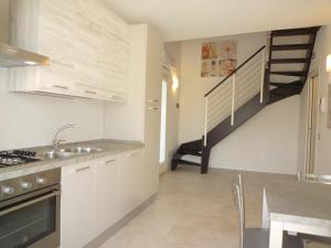 a kitchen with a sink and a staircase at Residence Le Palme in Lido di Jesolo