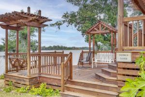 una terraza de madera con cenador en un lago en Lakefront Panama City Studio with Hot Tub Access, en Panama City