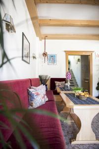 ein Wohnzimmer mit einem roten Sofa und einem Tisch in der Unterkunft Sonnenberg in Schlanders