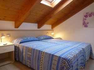 a bedroom with a bed with a blue comforter at Residence Le Palme in Lido di Jesolo