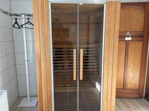 uma porta de madeira com painéis de vidro num quarto em Villa Louise em Stavelot