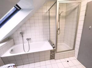 La salle de bains est pourvue d'une douche et d'une baignoire. dans l'établissement Ferienhaus Hühnergott mit großem Garten familienfreundlich, à Garz